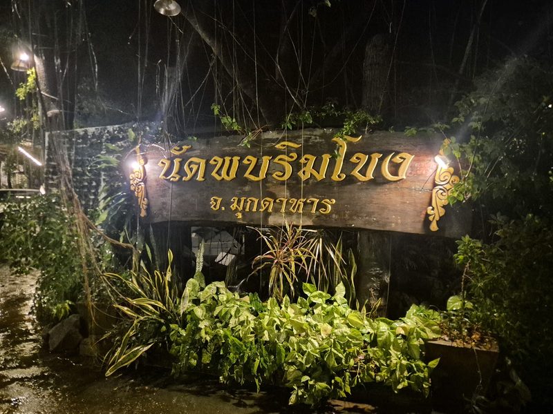ป้ายไม้แกะสลัก นัดพบริมโขง จ.มุกดาหาร เปิดไฟตอนกลางคืนท่ามกลางต้นไม้